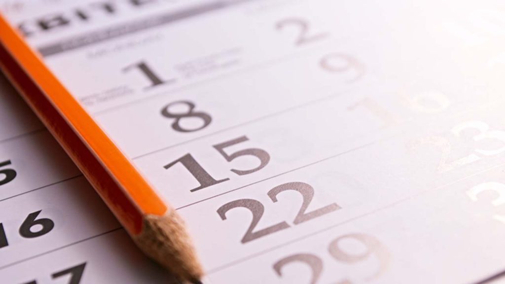Close-up of a sharp pencil on the page of a calendar, in order to mark days with events